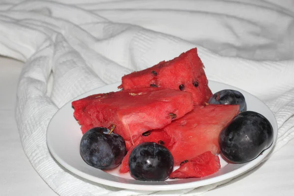 Slices Bright Red Ripe Watermelon Plum White Plate Photo White — Stock Photo, Image