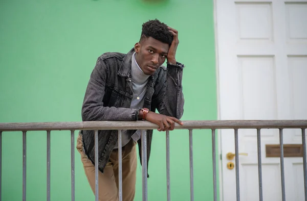 Stilvoller junger Mann lehnt an Geländer — Stockfoto