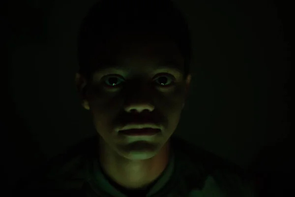 Közelkép egy fiatal fiúról a sötét szobában. — Stock Fotó