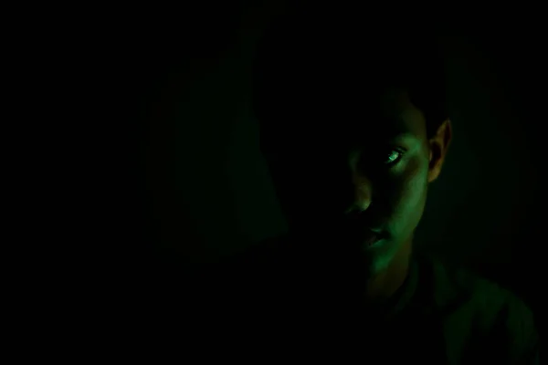 Portrait of teenager staring in dark room — Stock Photo, Image