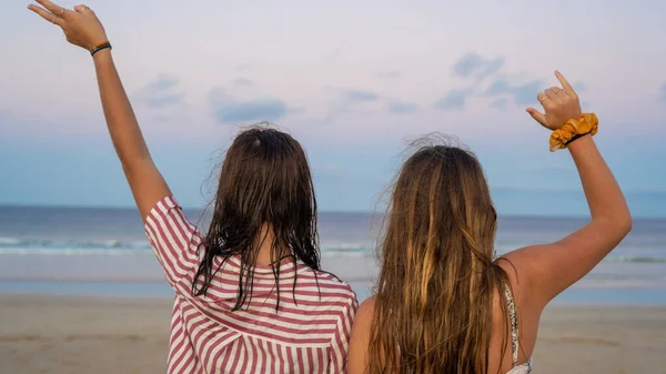 Vista trasera de dos chicas mostrando gesto de la mano en la emoción — Foto de Stock