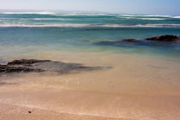 浪涌向海岸线，岩石从水里突出 — 图库照片