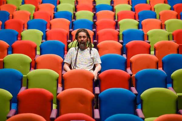 Mann mit Dreadlocks sitzt allein auf Stuhl — Stockfoto