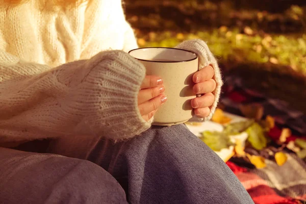 Dívka v teplém bílém svetru drží šálek kávy. Podzimní pozadí, koncept tepla a pohodlí — Stock fotografie