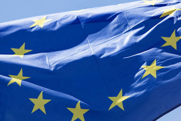 European flag in close up, in front of blue sky