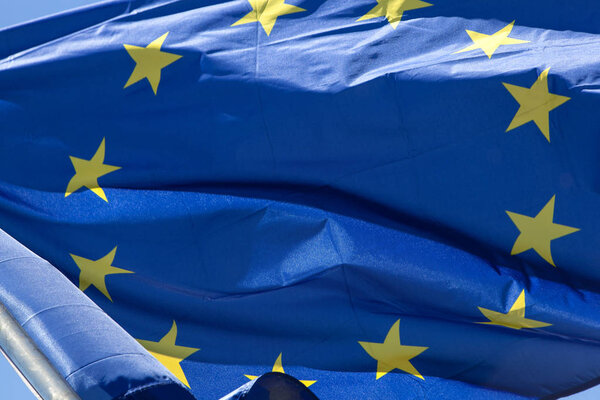 European flag in close up, in front of blue sky