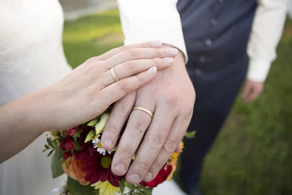 Händerna Bruden Och Brudgummen Med Blombukett Och Vigselringar — Stockfoto