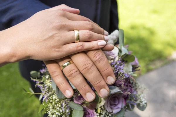 Manos de novia y novio con ramo de flores — Foto de Stock