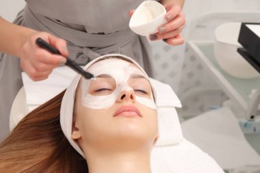 genç bir kadının bir kozmetik salonda yüz tedavi