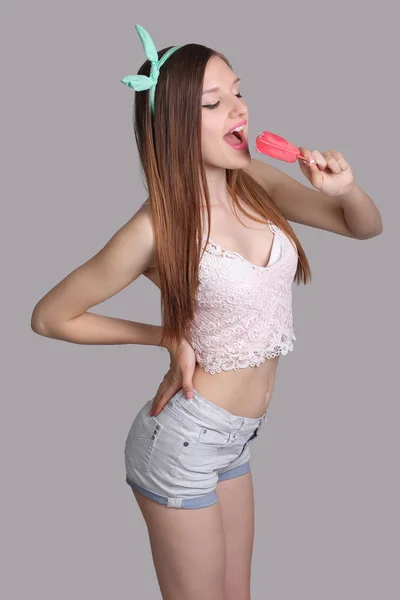 灰色背景粉红色冰淇淋的年轻女孩 — 图库照片