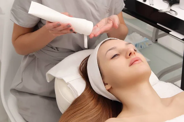 facial treatment of a young woman in a cosmetology salon