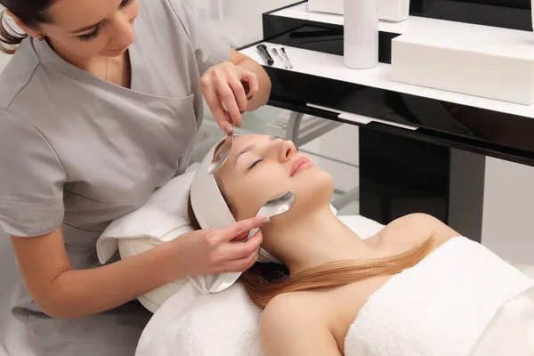 facial treatment of a young woman in a cosmetology salon