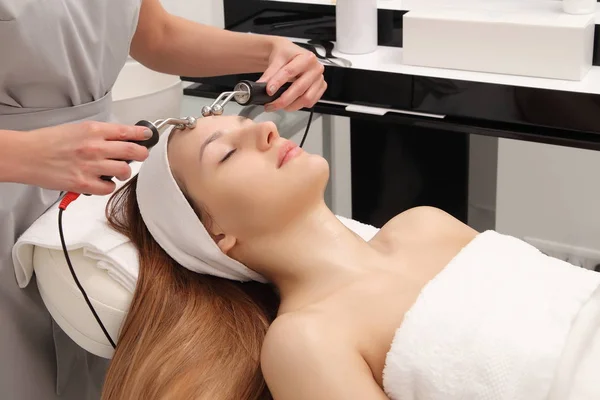 facial treatment of a young woman in a cosmetology salon