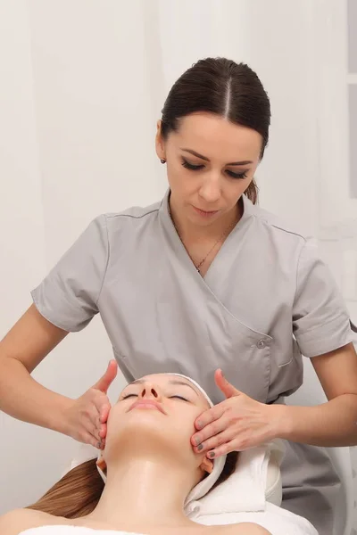 facial treatment of a young woman in a cosmetology salon