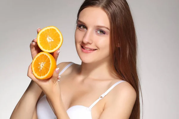 年轻快乐的女孩摆着橙色的一半 — 图库照片