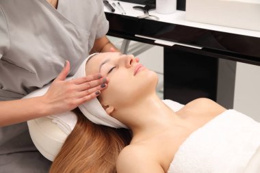 Güzel kadına bir spa salonu yüz masajı.