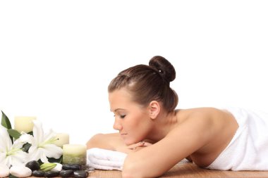 Bir kadın masaj yatağında uzanıp dinleniyor.