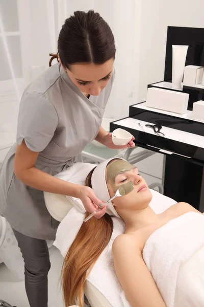 facial treatment of young woman in a cosmetology salon