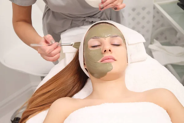 facial treatment of young woman in a cosmetology salon