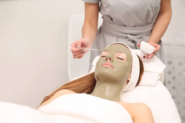 facial treatment of young woman in a cosmetology salon