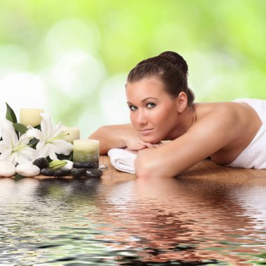 Bir kadın masaj yatağında uzanıp dinleniyor.