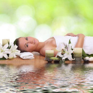 Bir kadın masaj yatağında uzanıp dinleniyor.