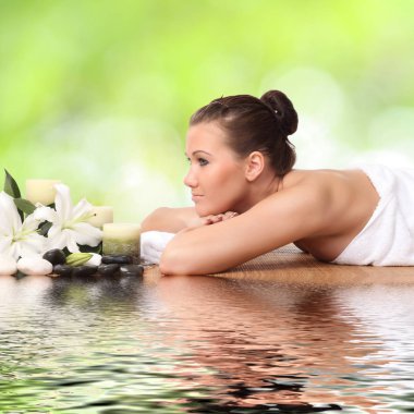 Bir kadın masaj yatağında uzanıp dinleniyor.