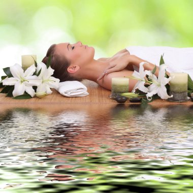 Bir kadın masaj yatağında uzanıp dinleniyor.