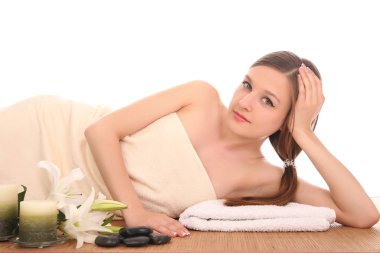 Bir kadın masaj yatağında uzanıp dinleniyor.