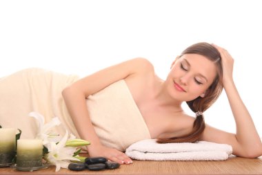 Bir kadın masaj yatağında uzanıp dinleniyor.