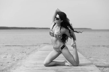 Genç ve güzeller güzeli bir kız seksi vücut bir sahilde meditasyon ile
