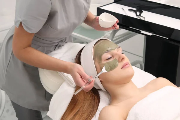 facial treatment of young woman in a cosmetology salon