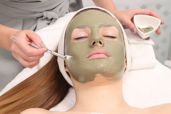 facial treatment of young woman in a cosmetology salon