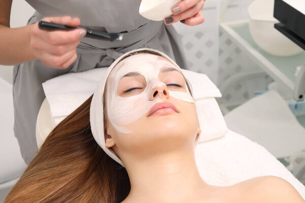 facial treatment of young woman in a cosmetology salon