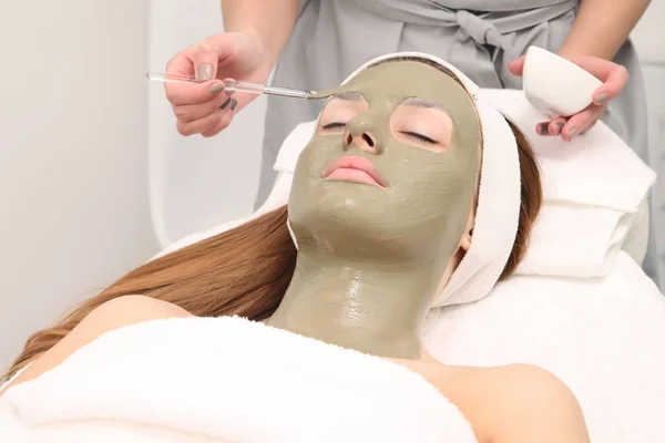 facial treatment of young woman in a cosmetology salon