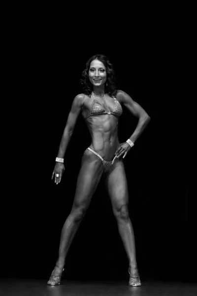 晒黑的肌肉健身模型在比基尼在黑色背景 — 图库照片