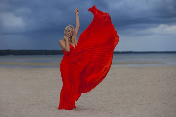 Giovane Ragazza Positiva Abito Rosso Brillante Uno Sfondo Paesaggio Nuvoloso — Foto Stock