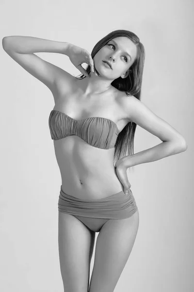 Slanke lichaam van een jonge vrouw in bikini op wit. Meisje met gezonde sportief figuur — Stockfoto