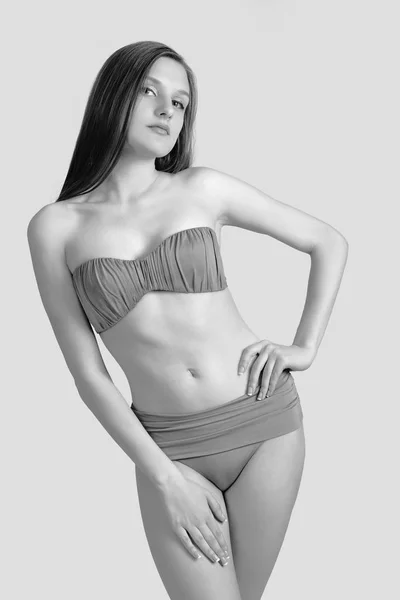 Schlanke junge Frau im Bikini auf weißem Grund. Mädchen mit gesunder sportlicher Figur — Stockfoto