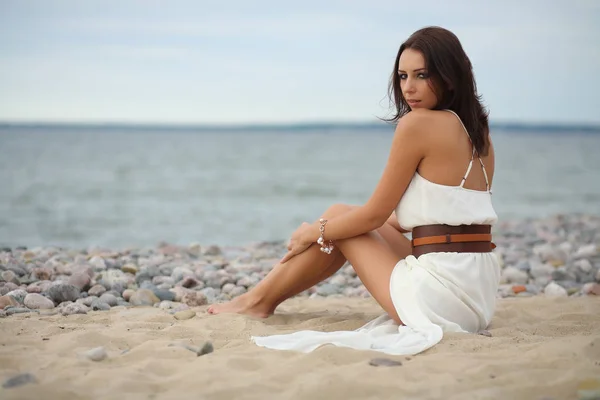 Чудова темноволоса дівчина в сукні на піщаному пляжі — стокове фото