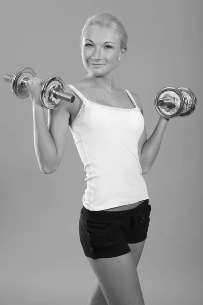 Fitness woman in doing exercises with dumbells. — Stock Photo, Image