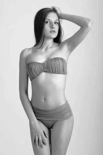 Smal kropp av ung kvinna i bikini på vitt. Flicka med frisk sportig figur — Stockfoto