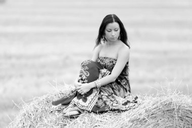 Genç özgür bir kadın samanlı bir tarlada