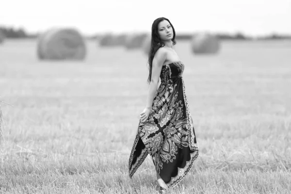 Jovem mulher livre em um campo com feno — Fotografia de Stock