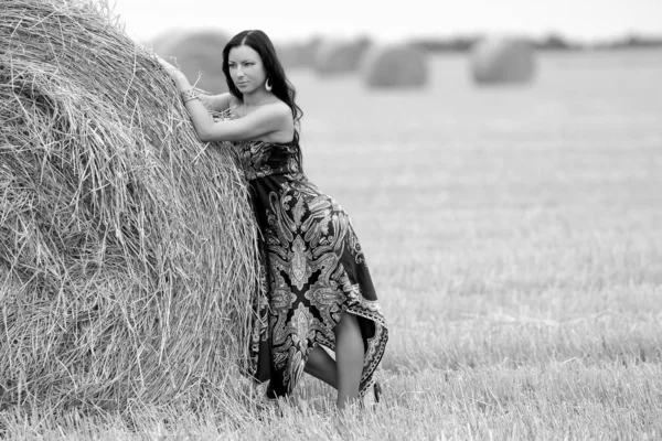 Giovane donna libera in un campo con fieno — Foto Stock