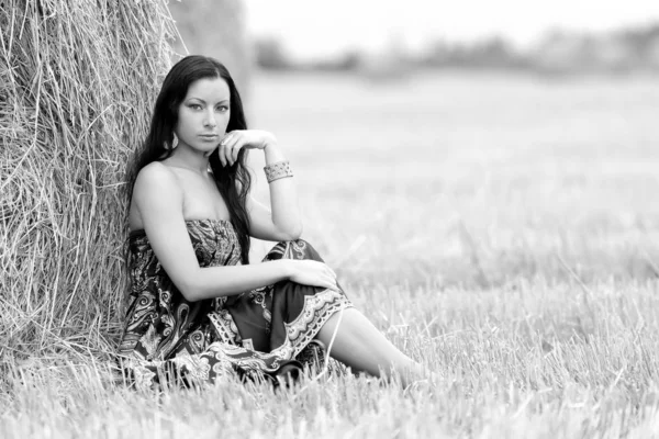 Joven mujer libre en un campo con heno —  Fotos de Stock