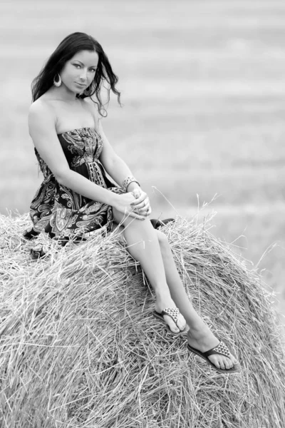 Jovem mulher livre em um campo com feno — Fotografia de Stock