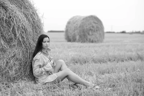 Junge freie Frau auf einem Feld mit Heu — Stockfoto