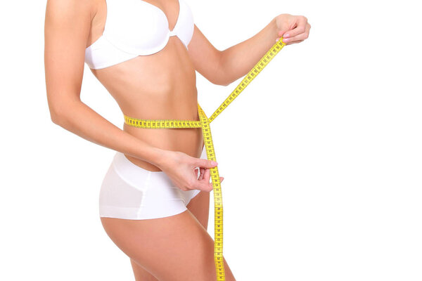 Женщина измеряет свое стройное тело
