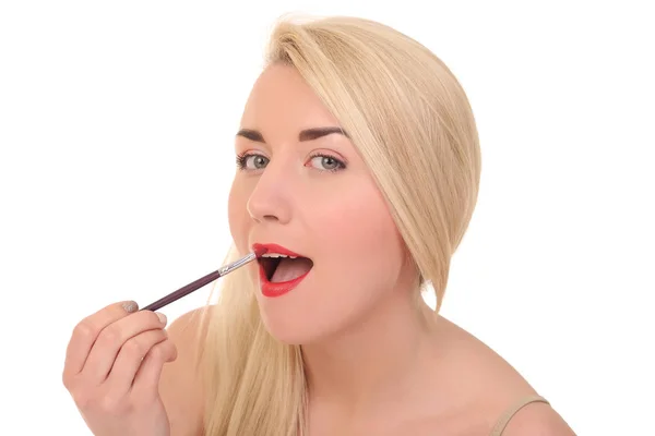 Mujer joven aplicando maquillaje de labios con cepillo cosmético —  Fotos de Stock